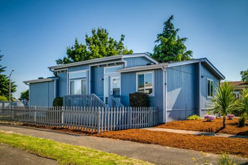A blue mobile home with a fence.